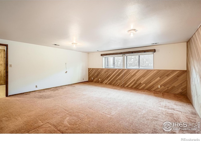 empty room with carpet floors and wood walls