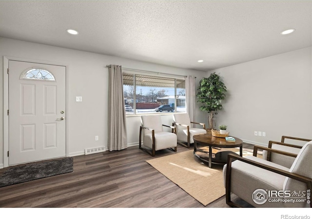 living room with dark hardwood / wood-style floors and a textured ceiling