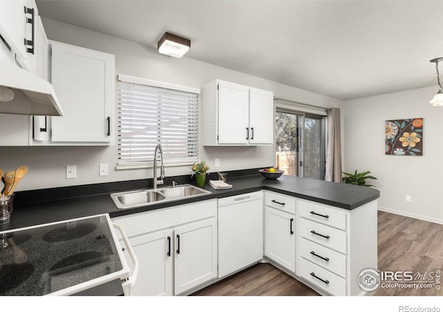 kitchen featuring white cabinetry, sink, hanging light fixtures, kitchen peninsula, and white appliances