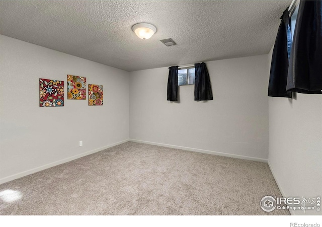 carpeted empty room with a textured ceiling