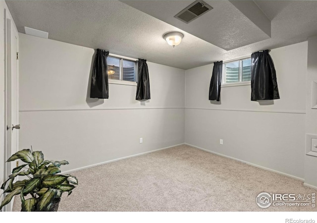 basement featuring a textured ceiling and carpet