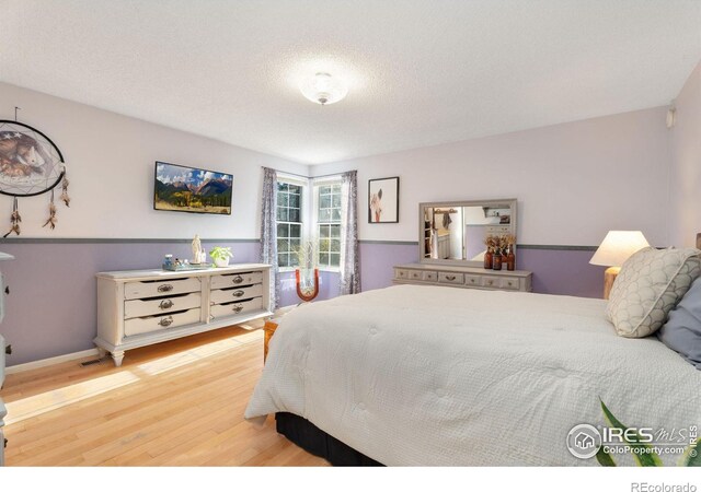 bedroom featuring a textured ceiling and light wood-type flooring