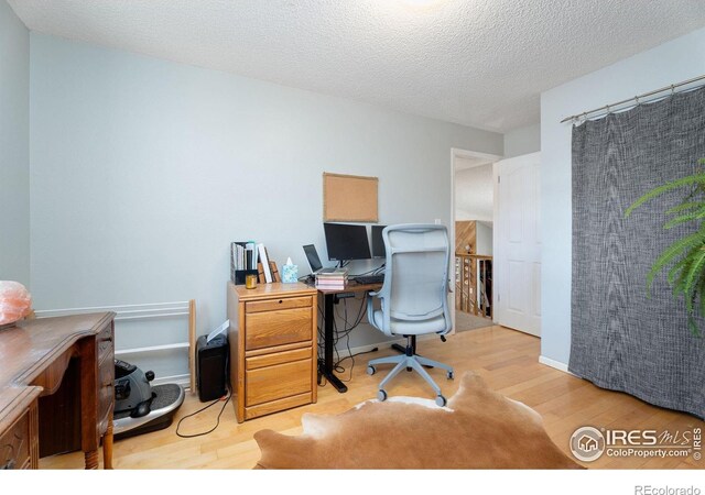 home office featuring a textured ceiling and light wood-type flooring