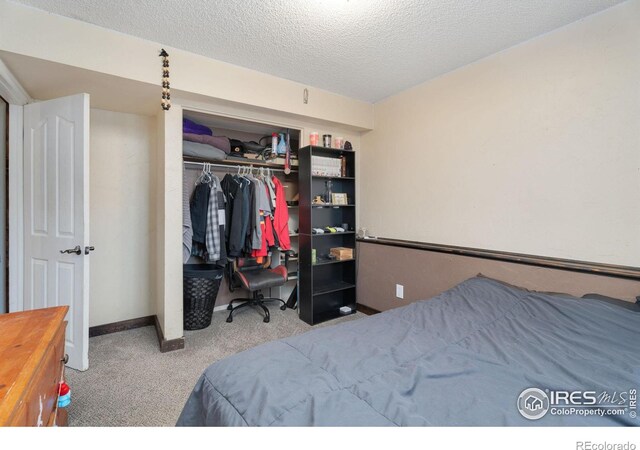 carpeted bedroom featuring a textured ceiling and a closet