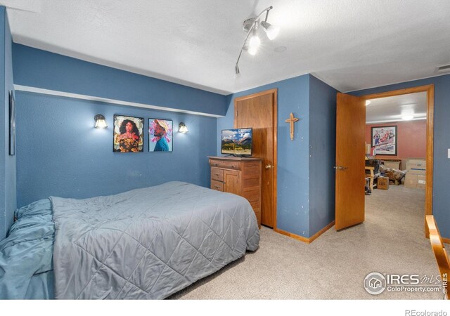 carpeted bedroom featuring ceiling fan and a textured ceiling