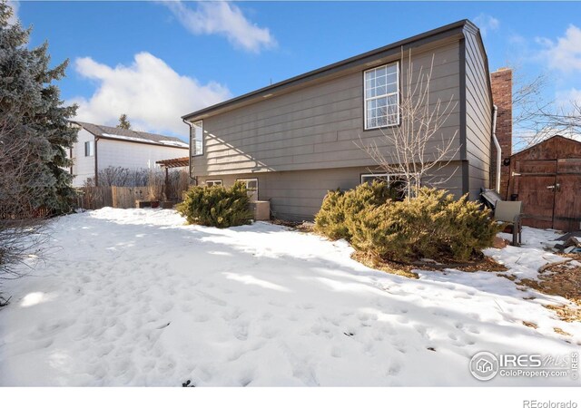 view of snowy exterior featuring a shed