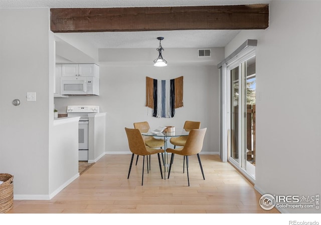 dining room featuring beam ceiling, light hardwood / wood-style flooring, and a textured ceiling