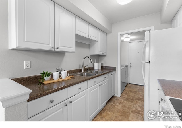 kitchen with white cabinetry, sink, washing machine and clothes dryer, and white appliances