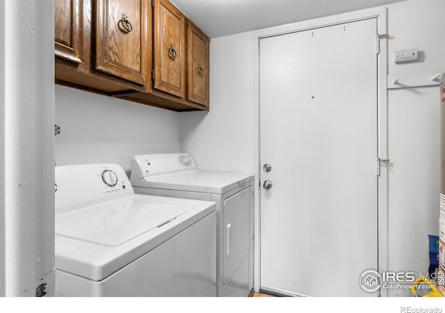 washroom featuring cabinets and washing machine and clothes dryer