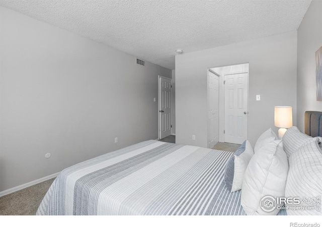 bedroom featuring light colored carpet and a textured ceiling