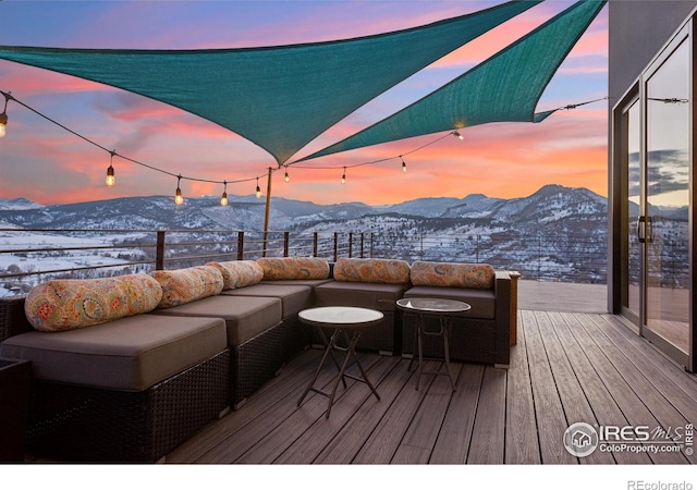 snow covered deck with an outdoor hangout area and a mountain view