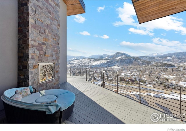 snow covered deck with an outdoor living space and a mountain view