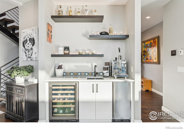 bar with sink, dark wood-type flooring, and wine cooler