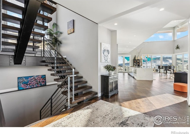 entryway with hardwood / wood-style floors and a high ceiling