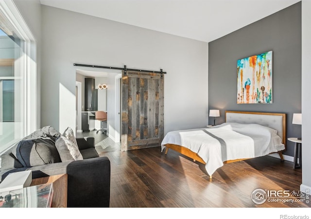 bedroom with hardwood / wood-style floors and a barn door