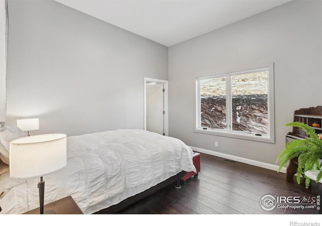 bedroom with dark hardwood / wood-style flooring