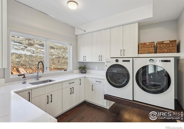 washroom featuring cabinets, dark hardwood / wood-style flooring, sink, and washing machine and clothes dryer