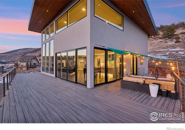 deck at dusk featuring a mountain view