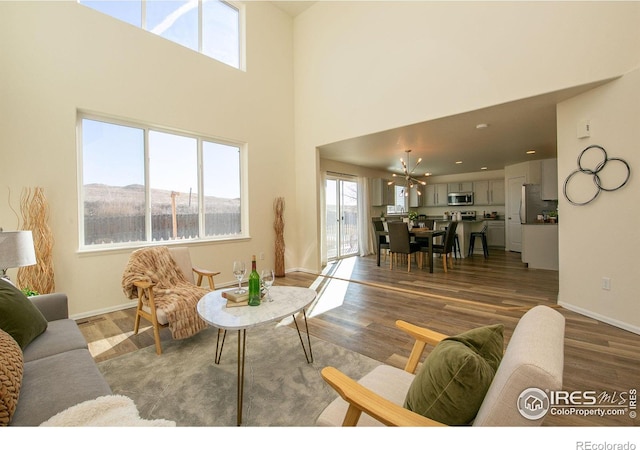 living room with a mountain view, hardwood / wood-style flooring, and a towering ceiling