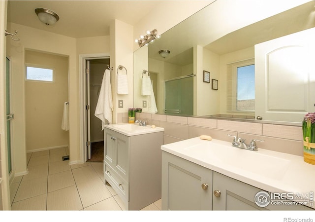 bathroom featuring vanity, tile patterned flooring, decorative backsplash, and walk in shower