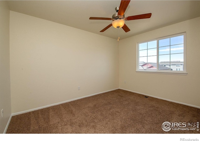 empty room featuring ceiling fan and carpet