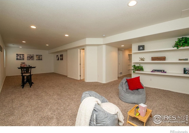 game room featuring light colored carpet and a textured ceiling