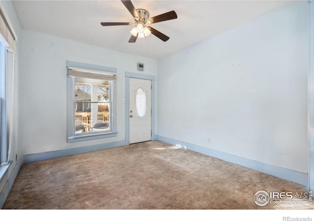 foyer featuring ceiling fan and carpet