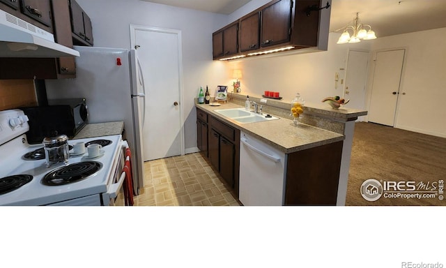 kitchen with under cabinet range hood, a peninsula, white appliances, a sink, and dark brown cabinets