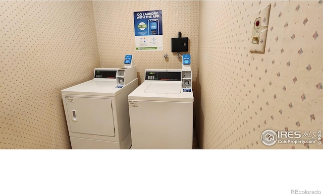 laundry area with washing machine and dryer and wallpapered walls