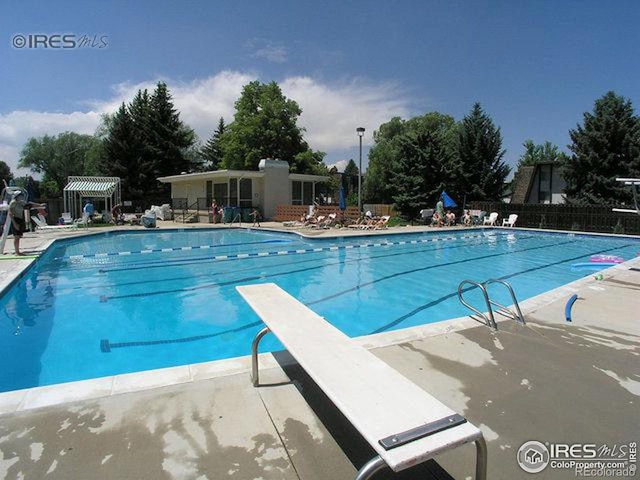 community pool featuring a diving board, fence, and a patio