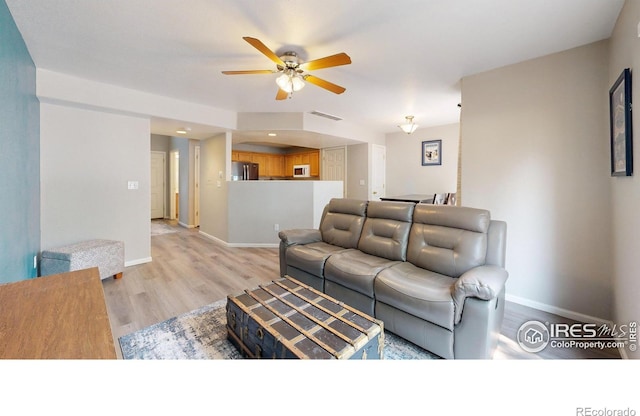 living room featuring light hardwood / wood-style flooring and ceiling fan