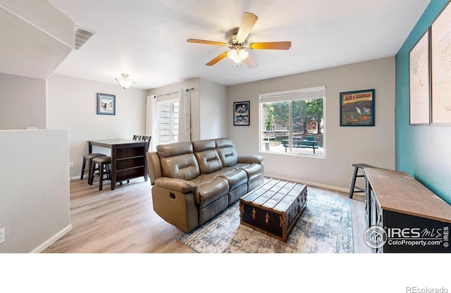 living room with ceiling fan and light wood-type flooring