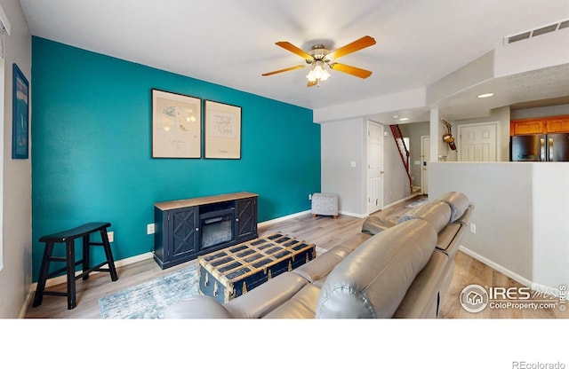 living room with ceiling fan and light hardwood / wood-style floors