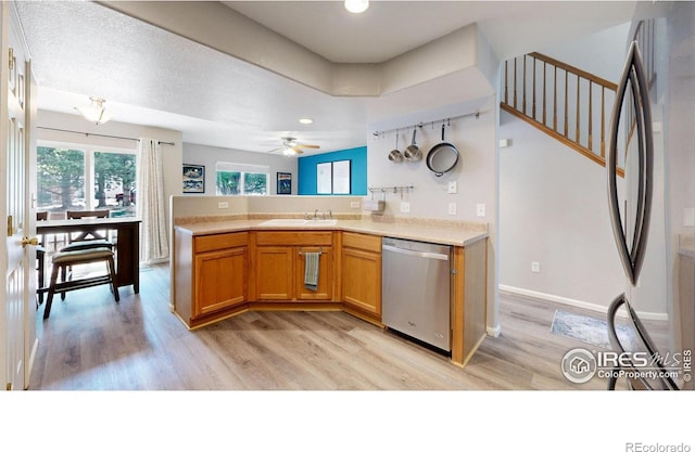 kitchen featuring sink, light hardwood / wood-style flooring, ceiling fan, appliances with stainless steel finishes, and kitchen peninsula