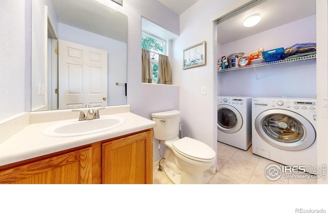 bathroom featuring vanity, tile patterned floors, independent washer and dryer, and toilet