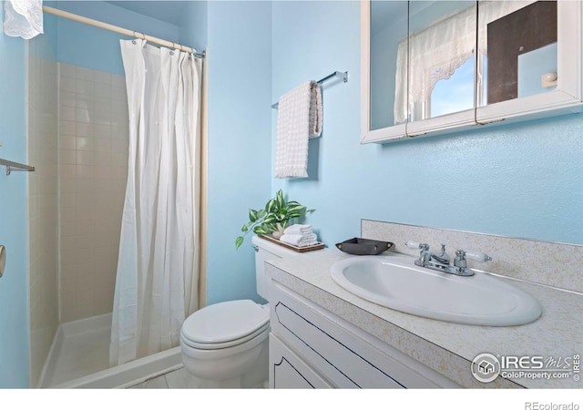 bathroom with vanity, curtained shower, and toilet