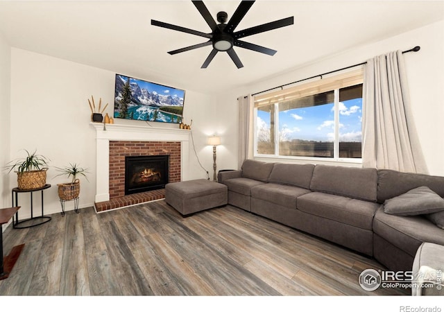 living room featuring hardwood / wood-style flooring, a brick fireplace, and ceiling fan