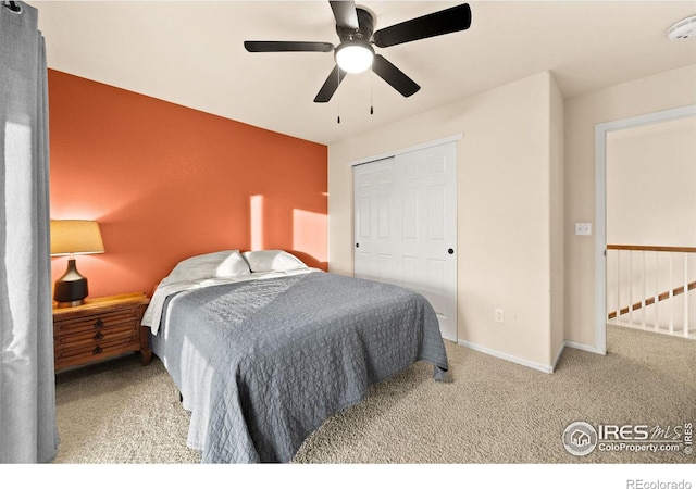 carpeted bedroom featuring ceiling fan and a closet