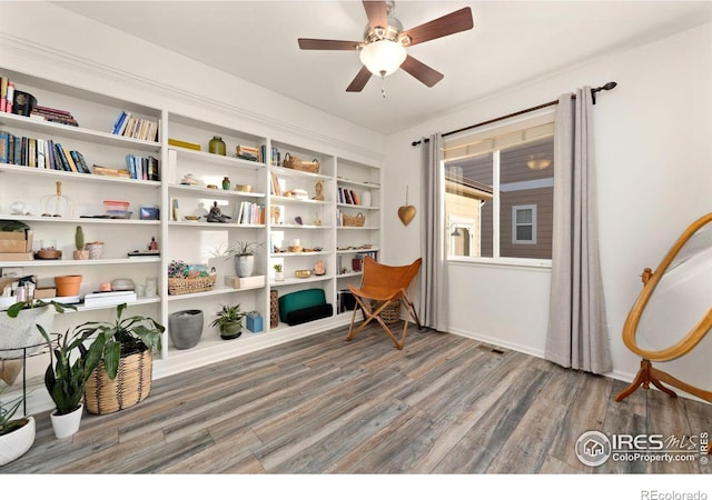 living area with wood-type flooring and ceiling fan