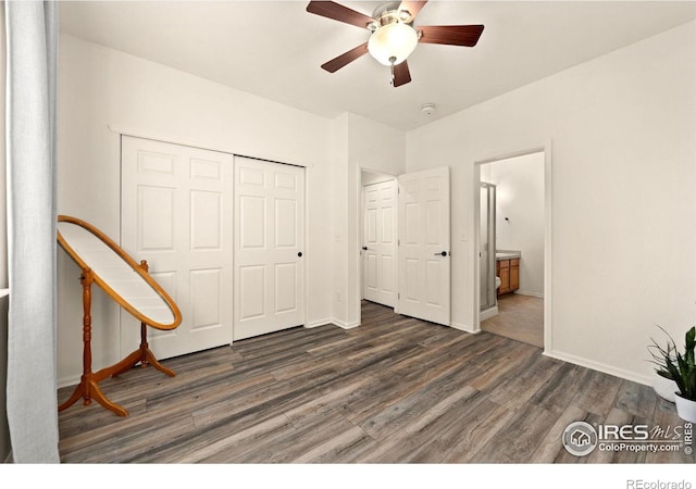 unfurnished bedroom featuring a closet, dark hardwood / wood-style floors, ceiling fan, and ensuite bathroom