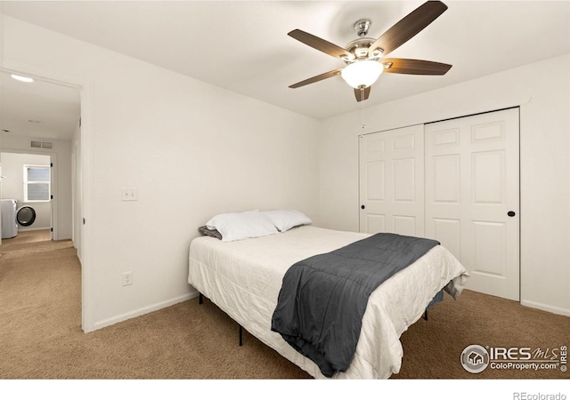 carpeted bedroom featuring ceiling fan, washer / clothes dryer, and a closet