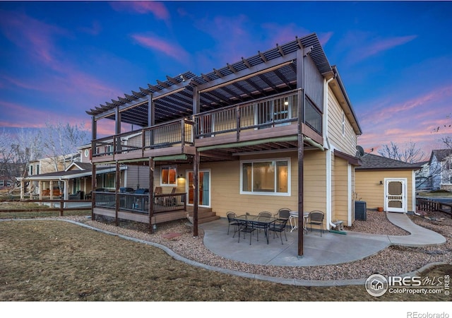 back house at dusk with cooling unit, a pergola, and a patio