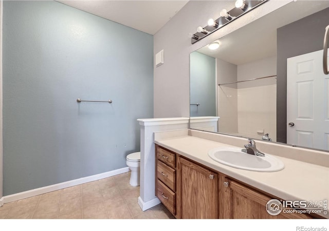 bathroom featuring vanity, tile patterned floors, toilet, and walk in shower