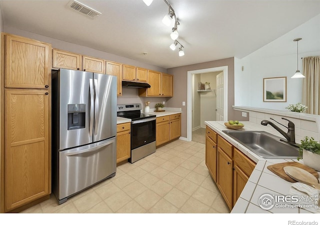 5756 N Genoa Way Unit 205, Aurora, CO 80019 - kitchen with appliances with stainless steel finishes, a sink, under cabinet range hood, hanging light fixtures, and baseboards