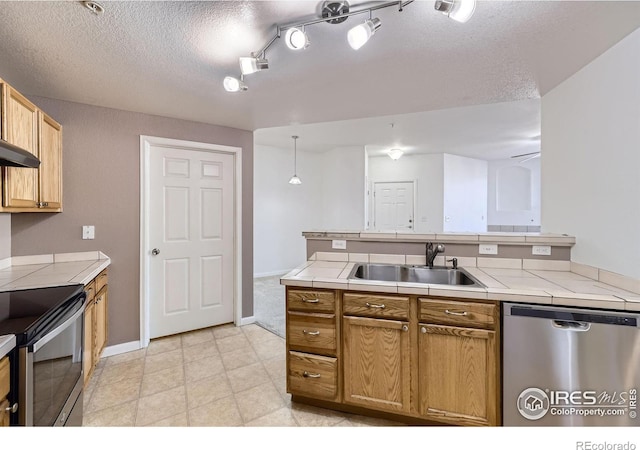 5756 N Genoa Way Unit 205, Aurora, CO 80019 - kitchen with stainless steel appliances, a sink, tile countertops, a textured ceiling, and baseboards
