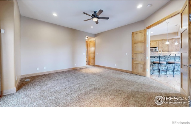 carpeted spare room with ceiling fan