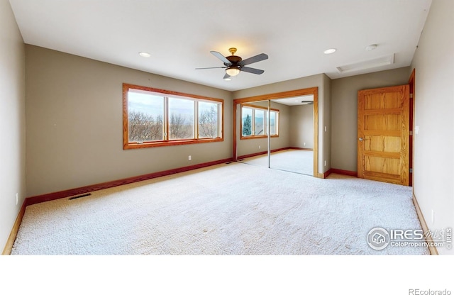 unfurnished bedroom featuring light colored carpet, a closet, and ceiling fan