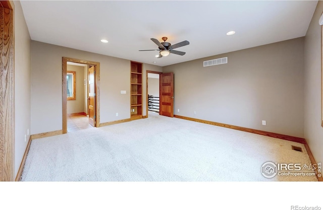 unfurnished bedroom with light carpet, ceiling fan, and ensuite bathroom