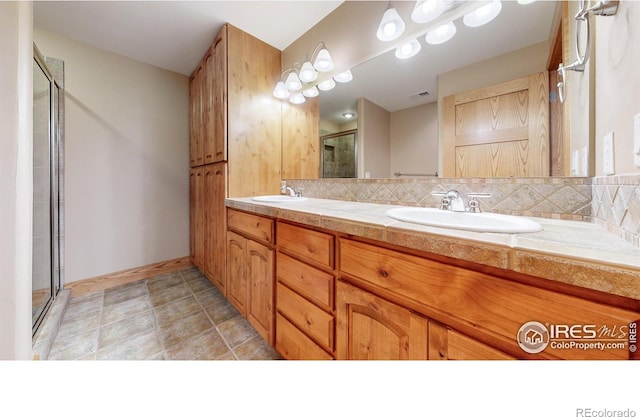 bathroom with vanity, backsplash, and a shower with shower door