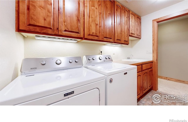 washroom with cabinets, sink, and washer and dryer